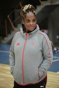 woman from waist up looking away from camera, hands in hoodie pockets, slight smile